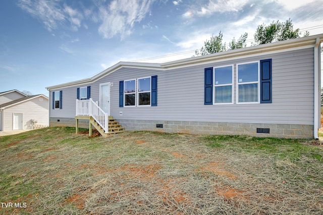 manufactured / mobile home with a front yard and crawl space