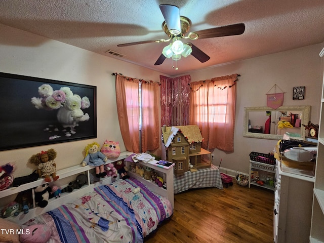 bedroom with a textured ceiling, dark hardwood / wood-style floors, and ceiling fan