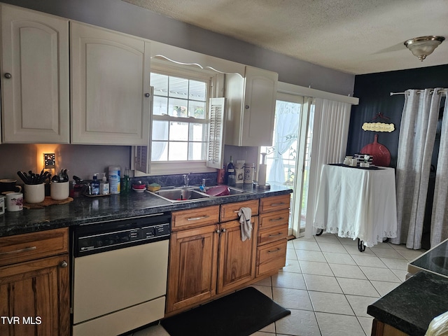 kitchen featuring sink, dishwasher, white cabinetry, and a textured ceiling