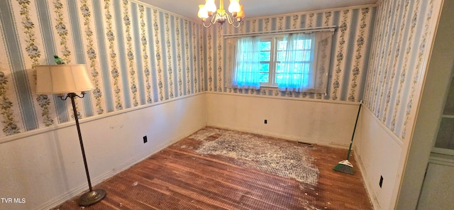 spare room featuring a chandelier and dark hardwood / wood-style flooring