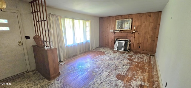 713 Woodhaven Dr, Johnson City, TN 37604 - unfurnished living room with wood walls, a healthy amount of sunlight, and a fireplace