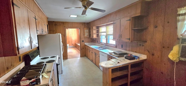 kitchen featuring wooden walls, sink, ceiling fan, and white appliances