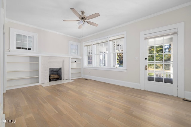 unfurnished living room featuring light hardwood / wood-style flooring, crown molding, a brick fireplace, and ceiling fan