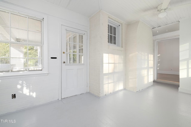 entryway with ceiling fan and concrete floors