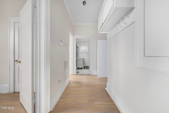 hallway featuring crown molding and light wood-type flooring