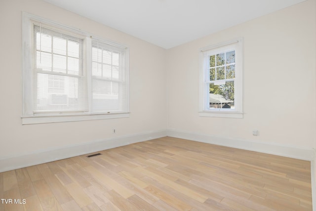 unfurnished room featuring a healthy amount of sunlight and light hardwood / wood-style flooring