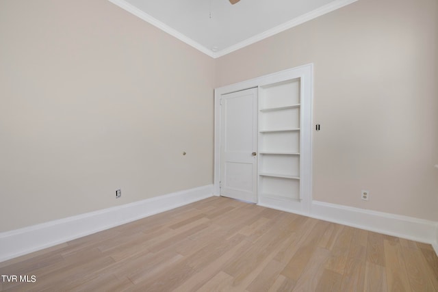 unfurnished bedroom featuring a closet, crown molding, light wood-type flooring, and ceiling fan