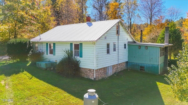 view of side of property with cooling unit and a lawn