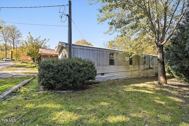 view of side of home with a yard