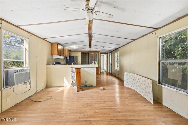 kitchen featuring kitchen peninsula, stainless steel fridge, ceiling fan, vaulted ceiling, and light hardwood / wood-style floors