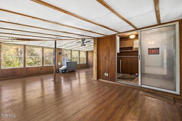 interior space with ceiling fan, hardwood / wood-style flooring, and wood walls