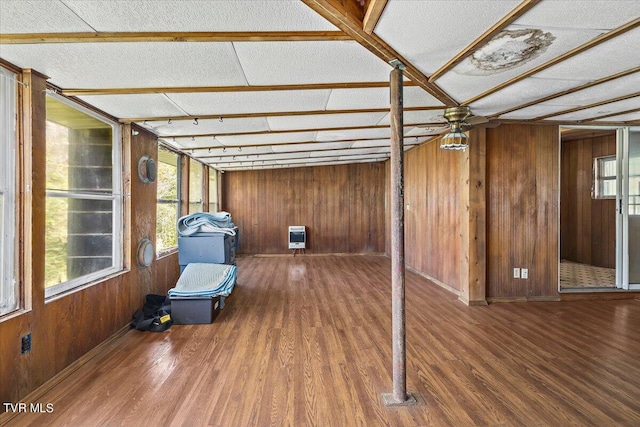 unfurnished sunroom featuring heating unit and ceiling fan