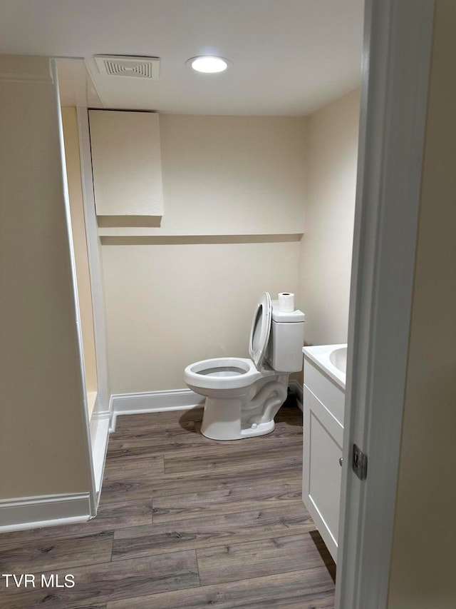 bathroom with vanity, toilet, and wood-type flooring