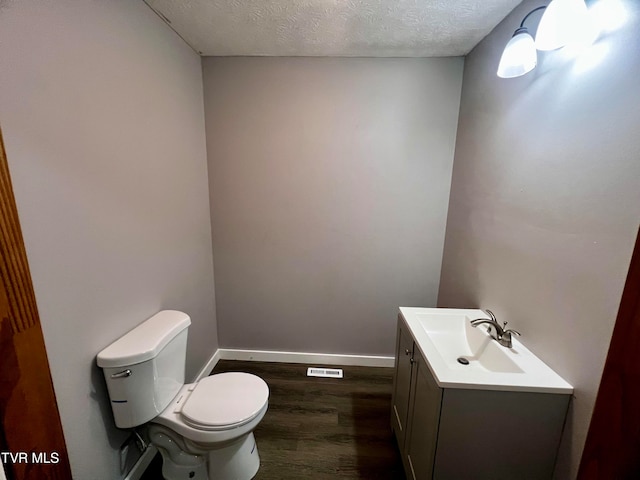 bathroom featuring hardwood / wood-style floors, vanity, a textured ceiling, and toilet