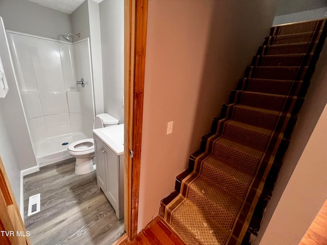 bathroom featuring walk in shower, toilet, vanity, and hardwood / wood-style flooring