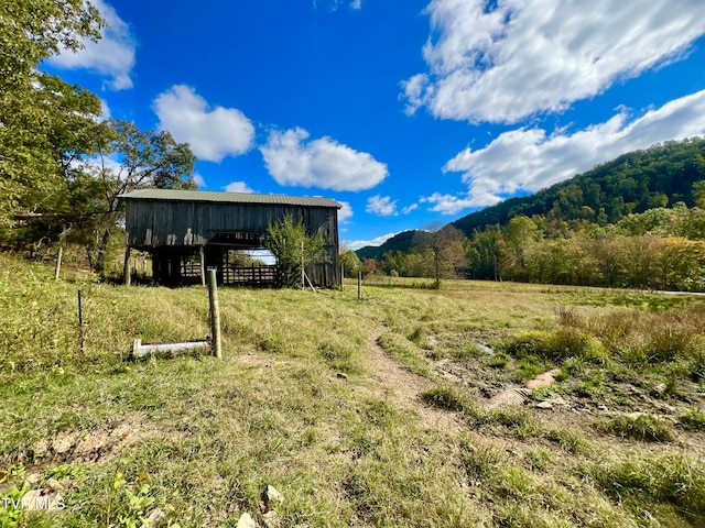 view of yard with a mountain view, a rural view, and an outbuilding