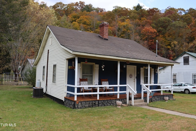 view of front of property with cooling unit, a front lawn, and covered porch