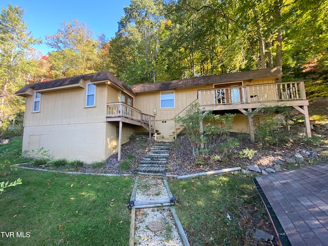 rear view of house with a deck and a lawn