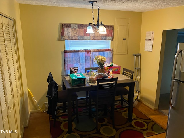 dining space with a chandelier, electric panel, a textured ceiling, and dark hardwood / wood-style flooring