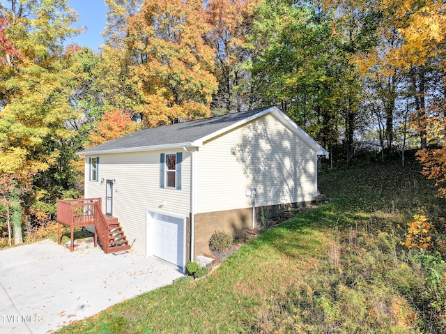 view of side of property featuring a deck, a lawn, and a garage