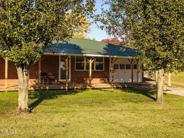 back of house with a yard, covered porch, and a garage