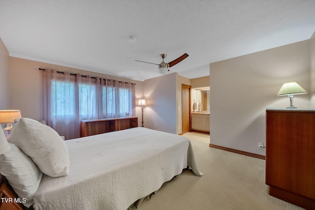 carpeted bedroom featuring ceiling fan and ensuite bath