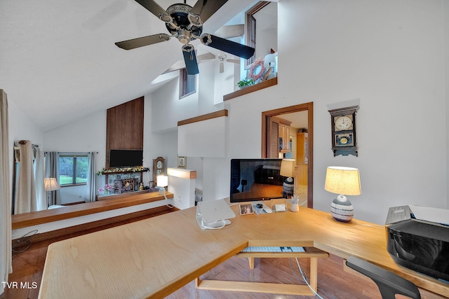 living room with wood-type flooring, high vaulted ceiling, and ceiling fan