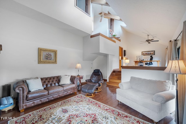 living room with ceiling fan, dark hardwood / wood-style flooring, and high vaulted ceiling