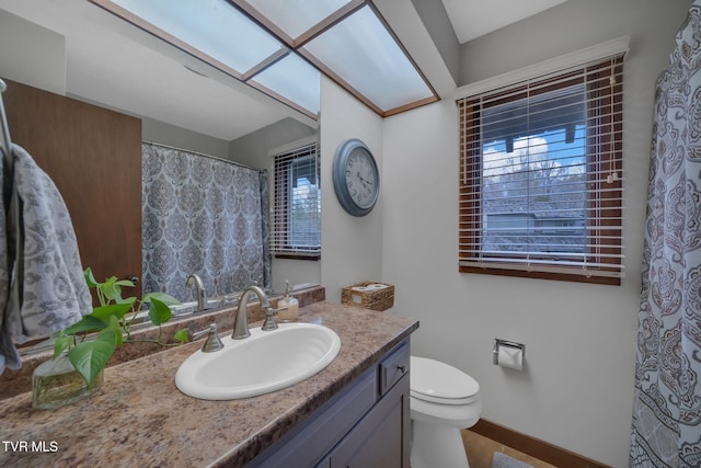 bathroom with a wealth of natural light, vanity, and toilet