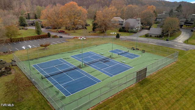 view of tennis court with a yard