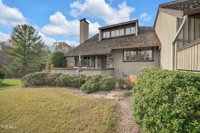 rear view of property featuring a lawn