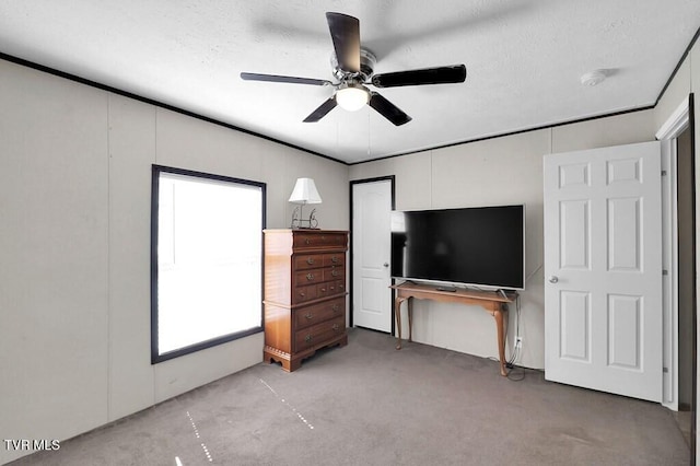 bedroom featuring a ceiling fan, a textured ceiling, and light carpet