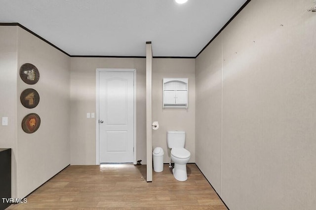 bathroom featuring crown molding, wood-type flooring, and toilet