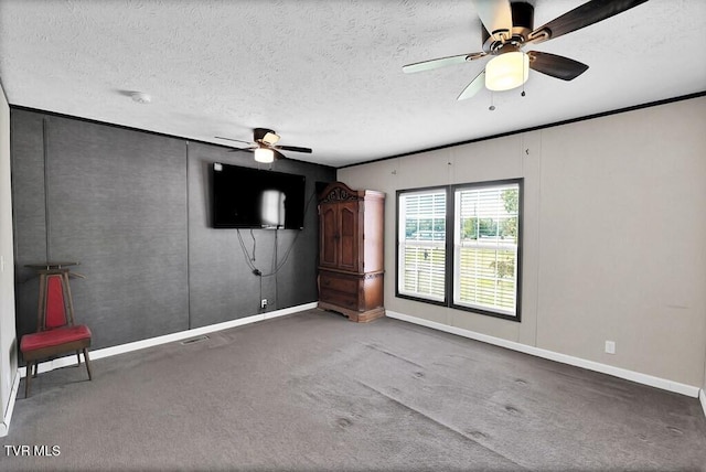carpeted empty room featuring baseboards, ceiling fan, a textured ceiling, and visible vents