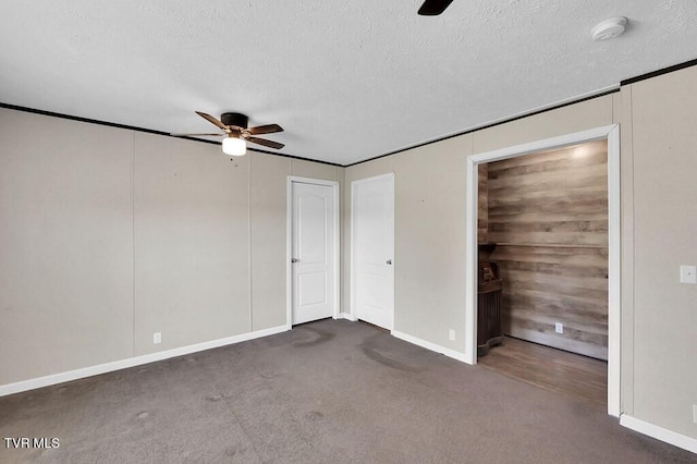 unfurnished bedroom with dark carpet, a textured ceiling, and ceiling fan