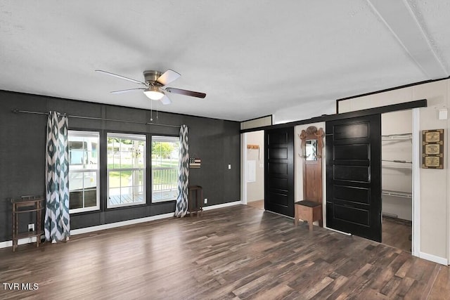 unfurnished living room with baseboards, a ceiling fan, and wood finished floors