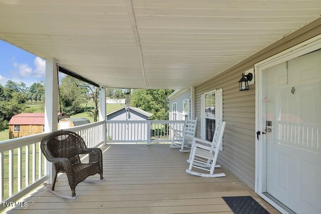 wooden deck featuring a storage unit and an outdoor structure