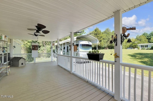 wooden terrace featuring a porch, a yard, and ceiling fan