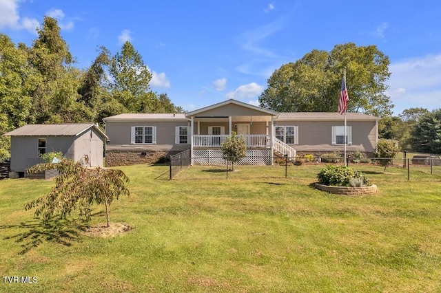 view of front of house with fence, a storage unit, a front lawn, an outbuilding, and metal roof