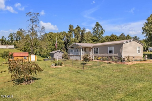 rear view of house with a lawn, an outdoor structure, a porch, and a storage unit