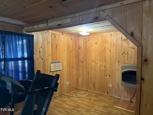 workout room featuring hardwood / wood-style floors, an AC wall unit, wooden walls, and heating unit