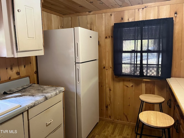 kitchen featuring wooden walls, wooden ceiling, and light wood-type flooring