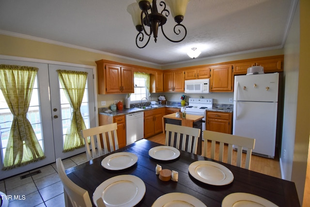 kitchen featuring french doors, ornamental molding, light tile patterned flooring, pendant lighting, and white appliances