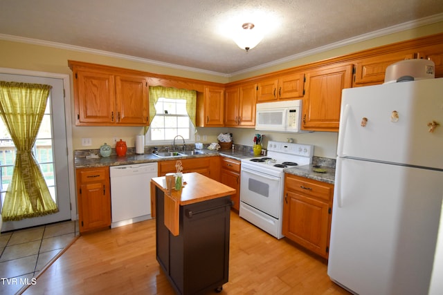 kitchen with crown molding, sink, a center island, light wood-type flooring, and white appliances