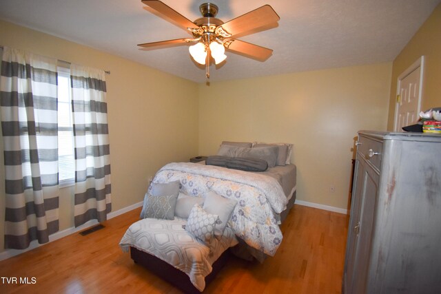 bedroom featuring light hardwood / wood-style flooring, multiple windows, and ceiling fan