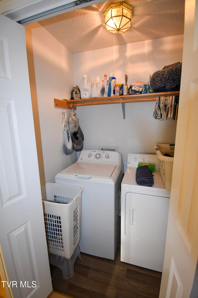 laundry room with a textured ceiling, washing machine and clothes dryer, and dark hardwood / wood-style flooring