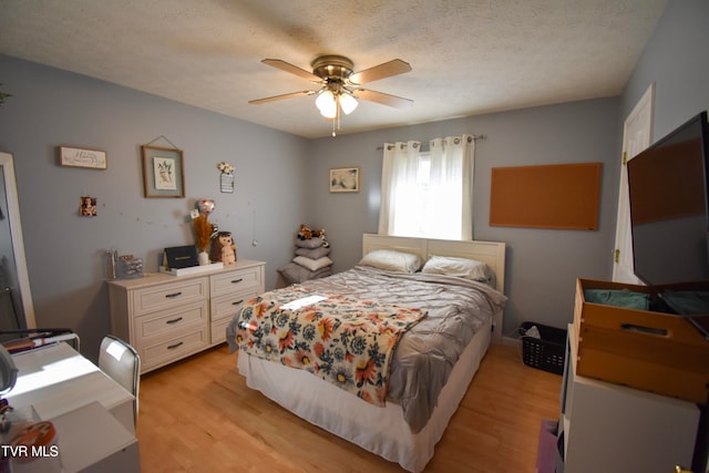 bedroom featuring a textured ceiling, light hardwood / wood-style floors, and ceiling fan