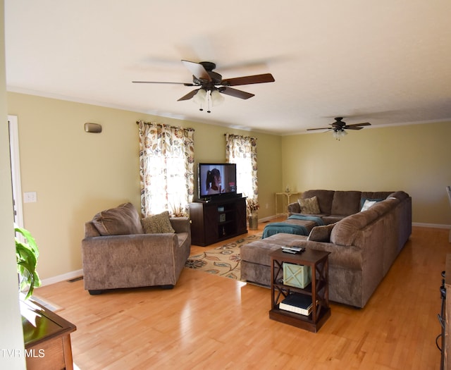 living room with ornamental molding, light wood-type flooring, and ceiling fan