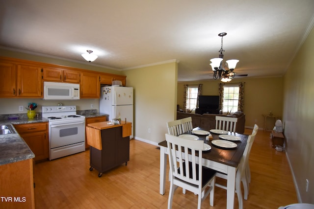 kitchen featuring white appliances, light hardwood / wood-style floors, crown molding, and hanging light fixtures