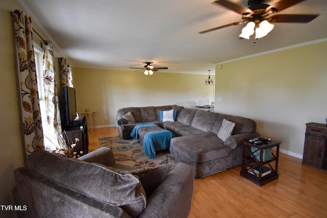 living room with light hardwood / wood-style floors, ornamental molding, and ceiling fan